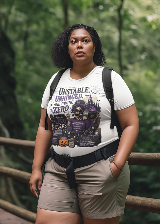 A woman wearing a white graphic t-shirt with a Halloween-themed design and the text 'UNSTABLE. UNHINGED.